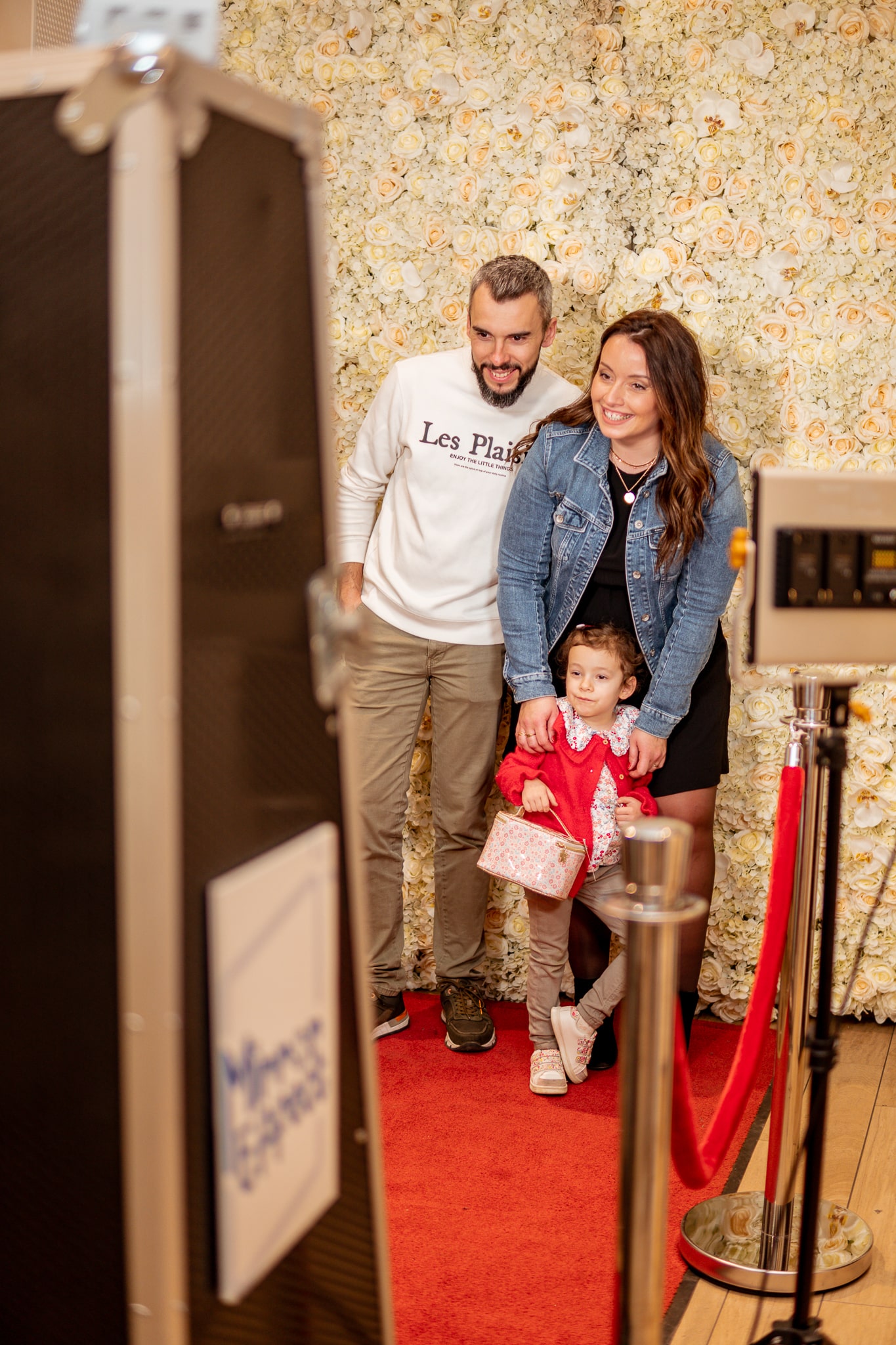 Décoration de baptême avec des fleurs blanches, des ballons pastel et un photobooth miroir.